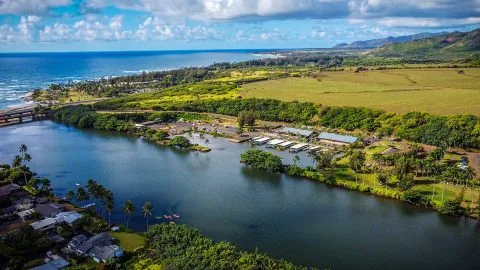 Drone view of Wailua River meeting the Pacific Ocean on Kauai’s east side, near the launch point for Kayak Adventures Kauai tours.