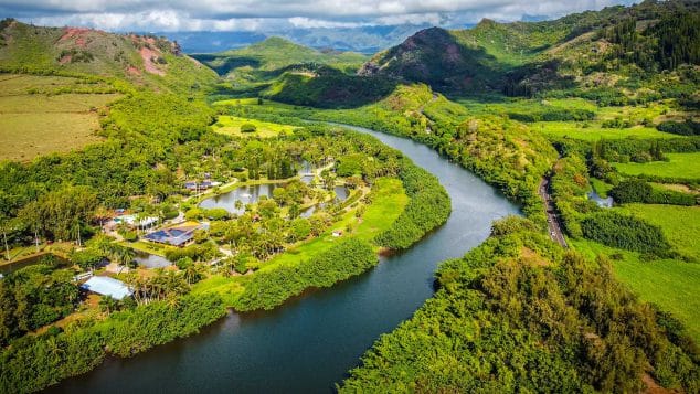 Drone view of Wailua River winding through Kauai's lush green landscape with Kayak Adventures Kauai tours.