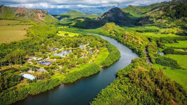 Drone view of Wailua River winding through Kauai's lush green landscape with Kayak Adventures Kauai tours.